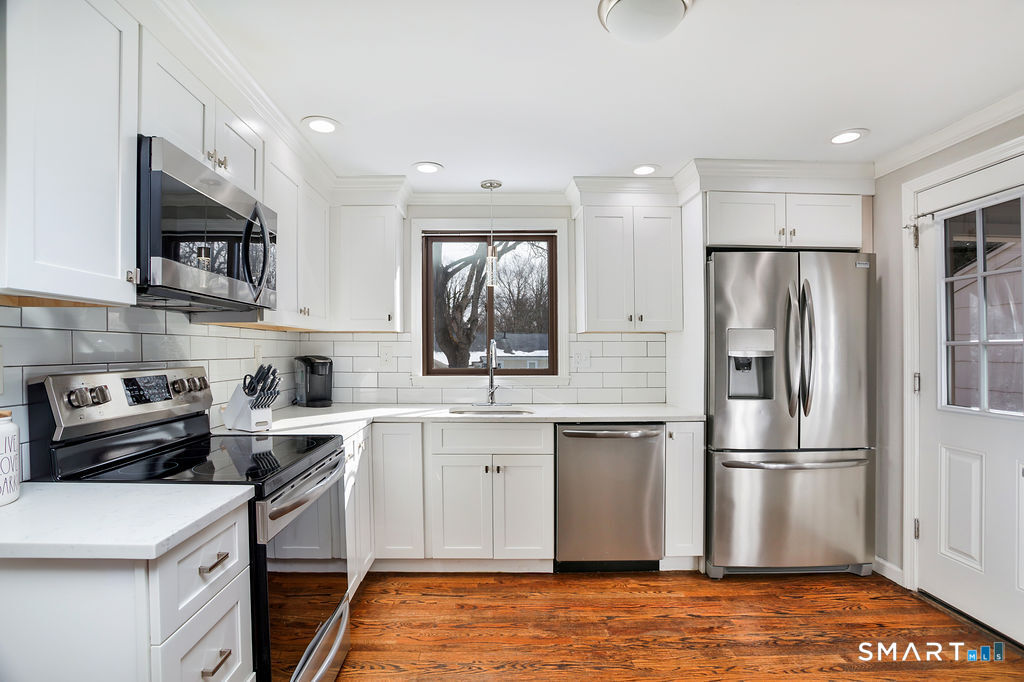 245 Reid Street Fairfield, CT 06824 - Photo 15 of 33 a kitchen with stainless steel appliances granite countertop a refrigerator a stove a sink and a microwave