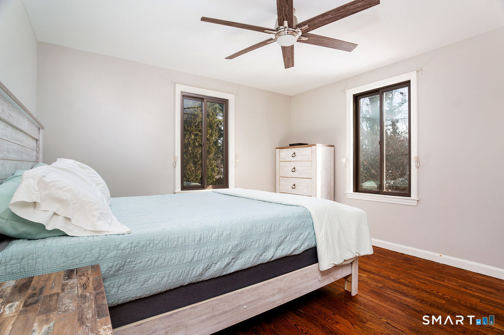 245 Reid Street Fairfield, CT 06824 - Photo 18 of 33 a bedroom with a bed and wooden floor