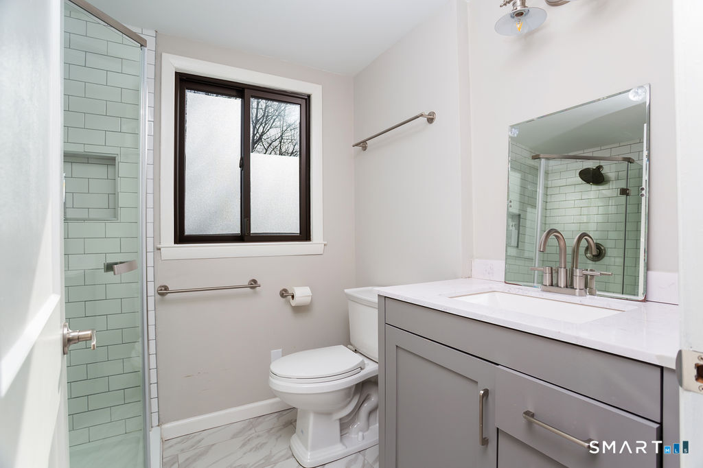 245 Reid Street Fairfield, CT 06824 - Photo 20 of 33 a bathroom with a toilet sink and mirror