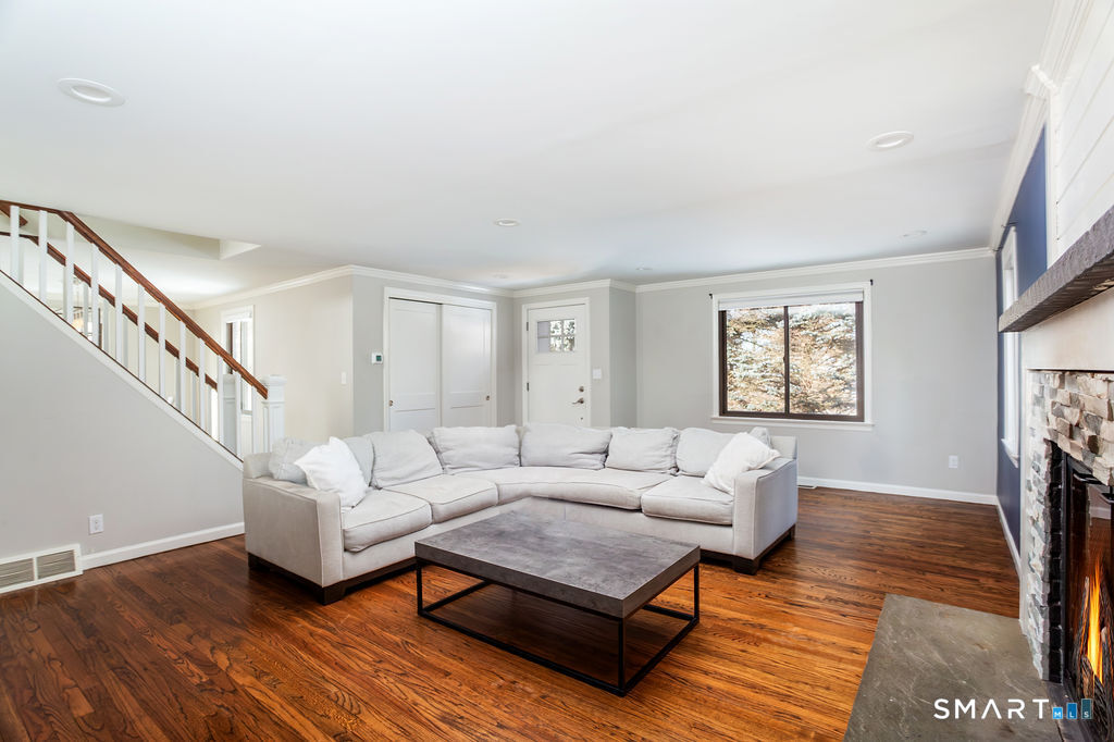 245 Reid Street Fairfield, CT 06824 - Photo 5 of 33 a living room with furniture a fireplace and a window