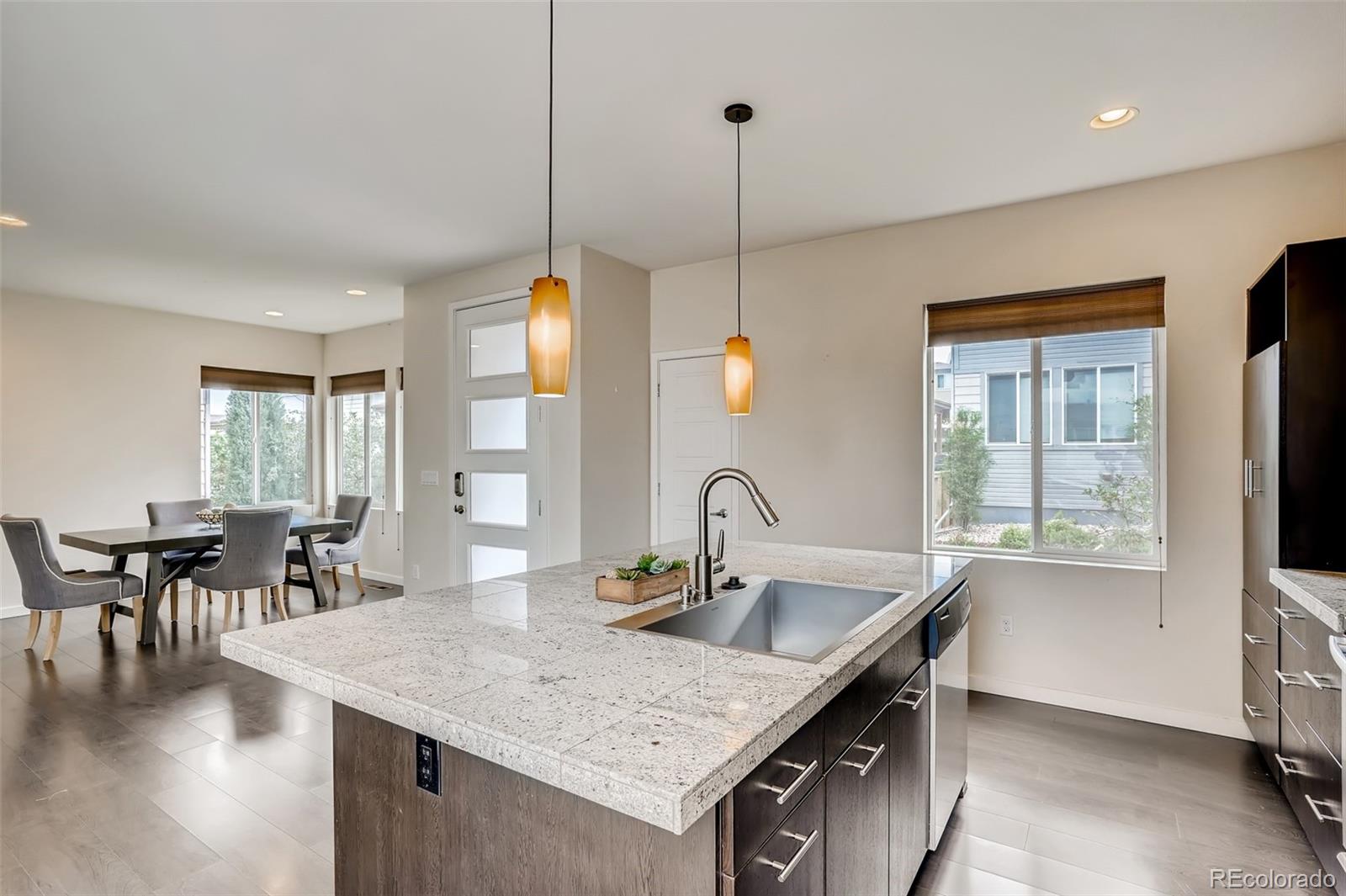 9817 Dunning Circle Highlands Ranch, CO 80126 - Photo 11 of 28 a kitchen with center island table and chairs in it