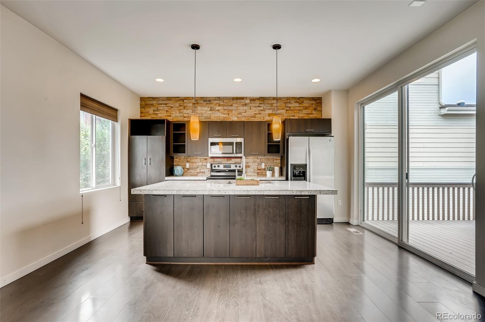 9817 Dunning Circle Highlands Ranch, CO 80126 - Photo 12 of 28 a view of kitchen with stainless steel appliances granite countertop sink stove and wooden floor