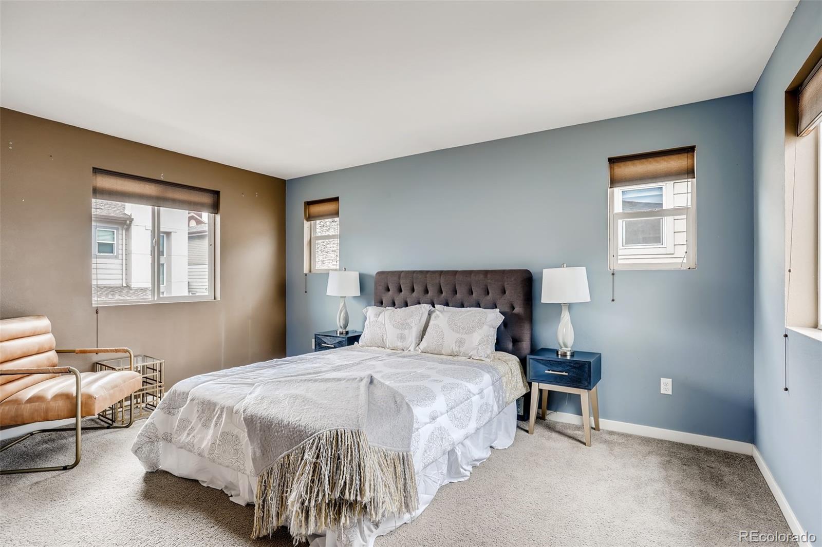 9817 Dunning Circle Highlands Ranch, CO 80126 - Photo 14 of 28 a bedroom with a bed and lamp