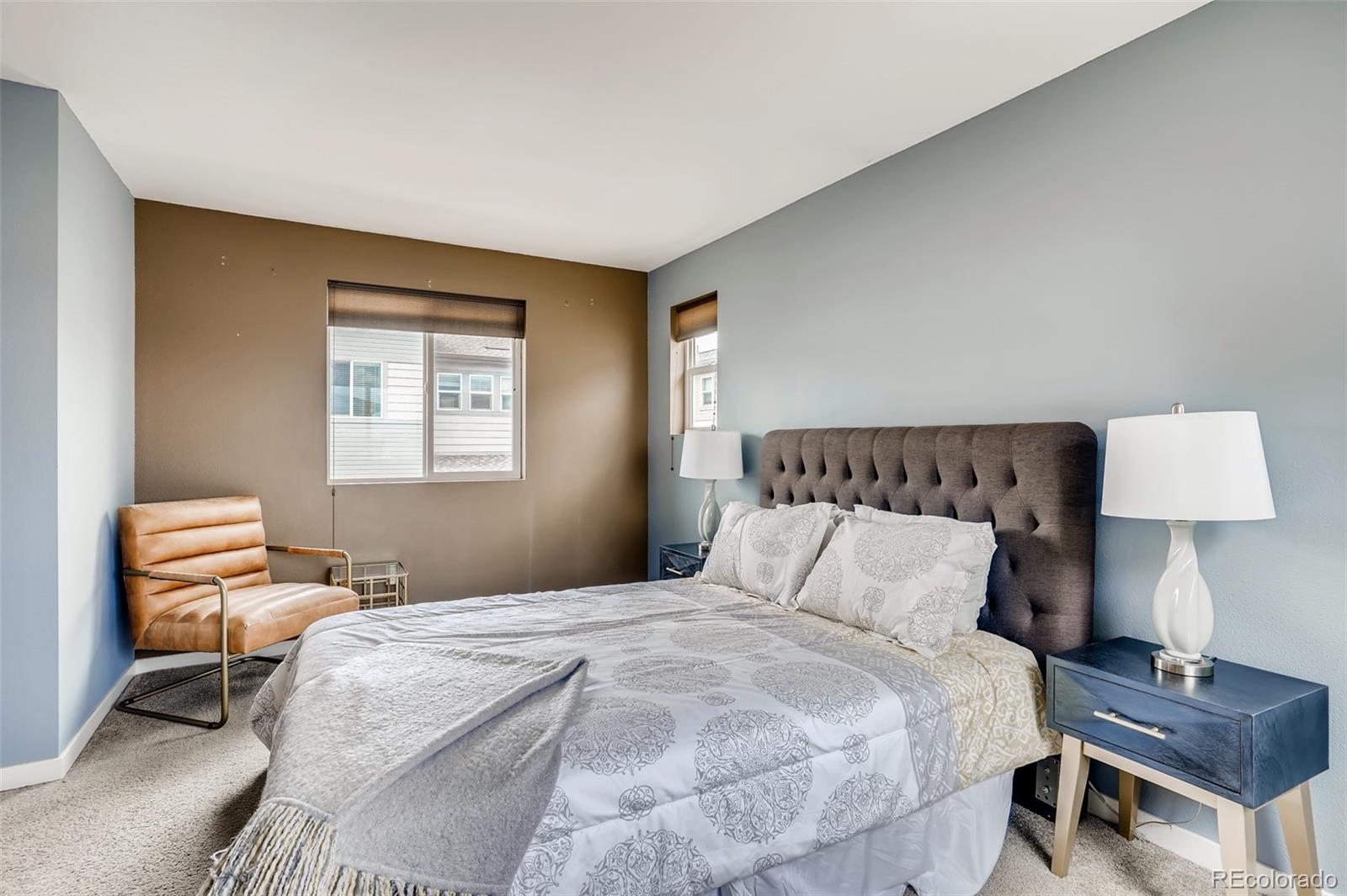 9817 Dunning Circle Highlands Ranch, CO 80126 - Photo 15 of 28 a bedroom with a bed and a lamp on table