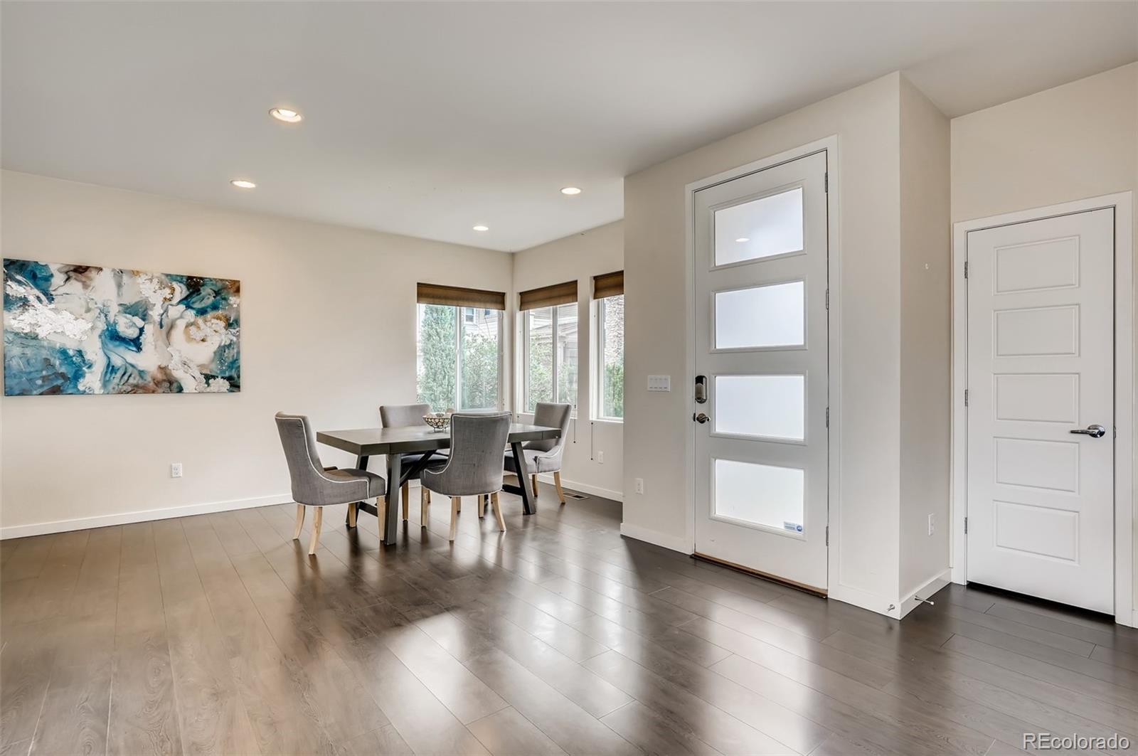 9817 Dunning Circle Highlands Ranch, CO 80126 - Photo 7 of 28 a dining room with furniture wooden floor a painting and a potted plant