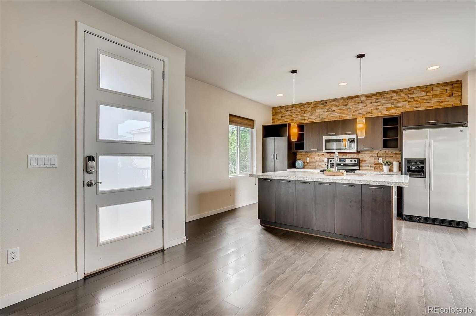 9817 Dunning Circle Highlands Ranch, CO 80126 - Photo 8 of 28 a kitchen with kitchen island a counter top space a sink stainless steel appliances and cabinets
