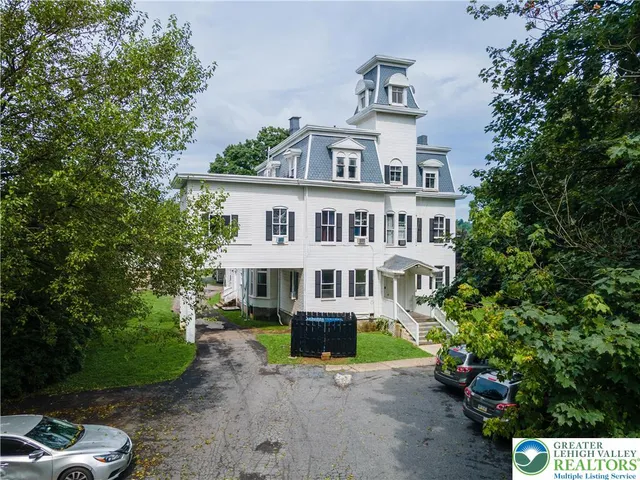 a front view of a house with a yard and potted plants
