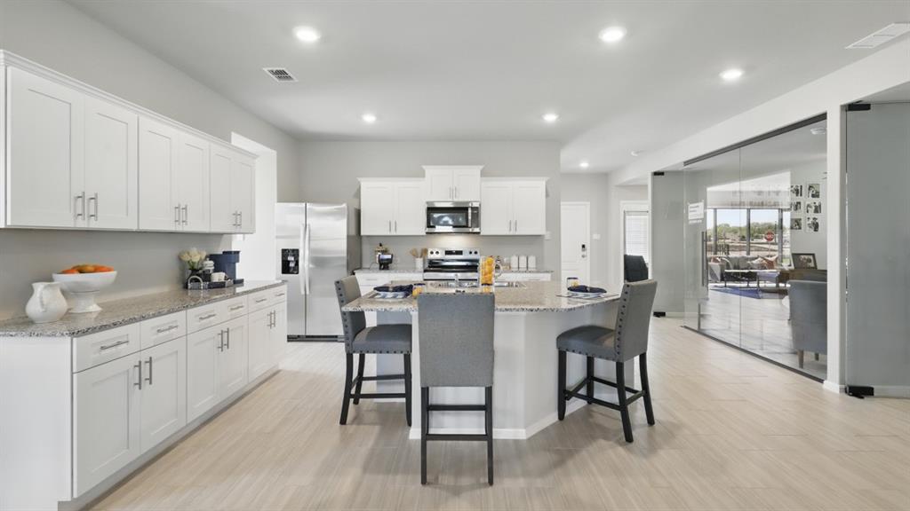 445 Blanco Drive Azle, TX 76020 - Photo 1 of 35 a kitchen with kitchen island granite countertop wooden cabinets and stainless steel appliances