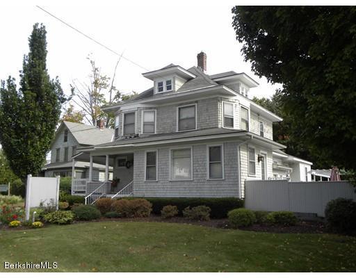 335 Federal Street Greenfield, MA 01301 - Photo 1 of 30 a view of a white house with large windows and a yard with plants and large trees