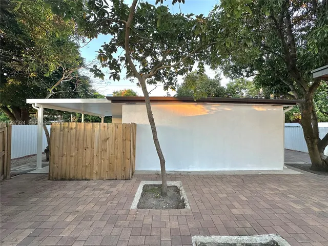 a view of balcony with wooden fence and large trees