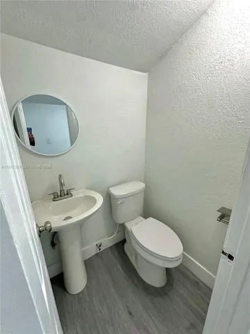 a bathroom with a toilet a sink and mirror