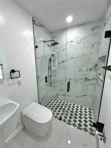 a bathroom with a toilet and a shower