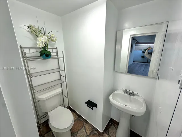 a bathroom with a toilet sink and mirror