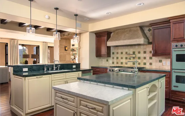 a kitchen with stainless steel appliances granite countertop a sink a stove and a refrigerator