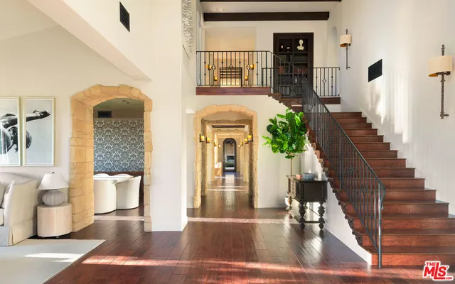 a view of an entryway with wooden floor leading to a furnished livingroom and living room