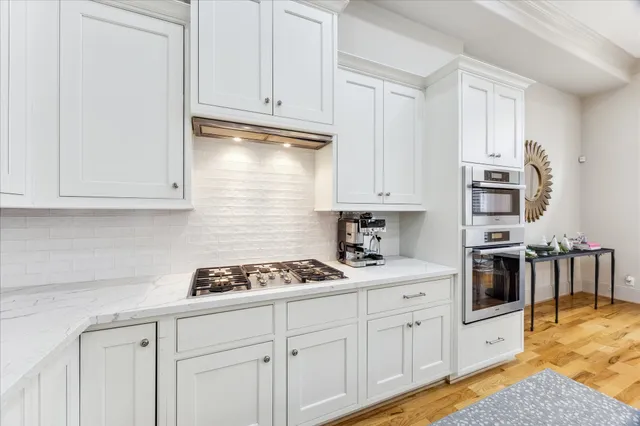 a kitchen with stainless steel appliances granite countertop a stove a sink and a refrigerator