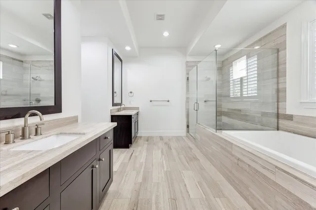 a spacious bathroom with a granite countertop sink a toilet a mirror and shower
