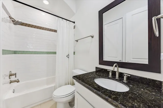 a bathroom with a granite countertop sink toilet a mirror and shower