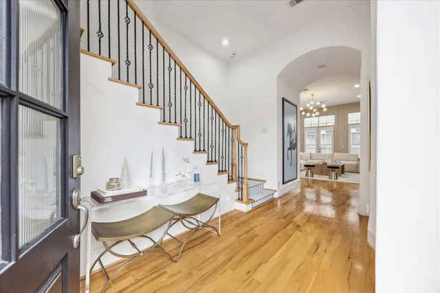 a dining room with wooden floor and a chandelier