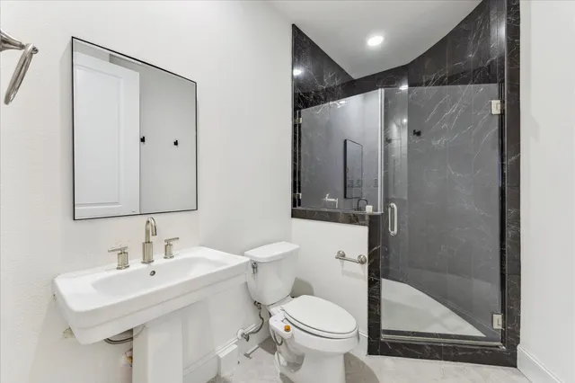 a bathroom with a sink toilet and shower