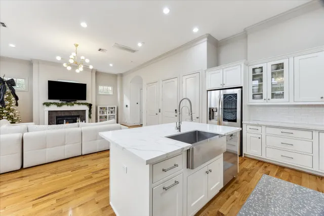 a large white kitchen with cabinets a sink and a stove