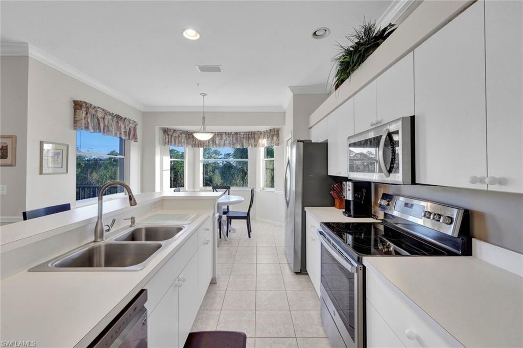 8680 Cedar Hammock Circle, Unit 142 Naples, FL 34112 - Photo 13 of 27 a kitchen with a stove a sink and a refrigerator