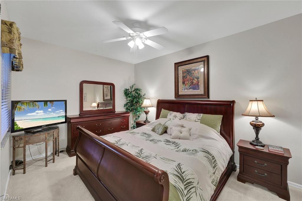 8680 Cedar Hammock Circle, Unit 142 Naples, FL 34112 - Photo 17 of 27 a bedroom with a bed and a chandelier
