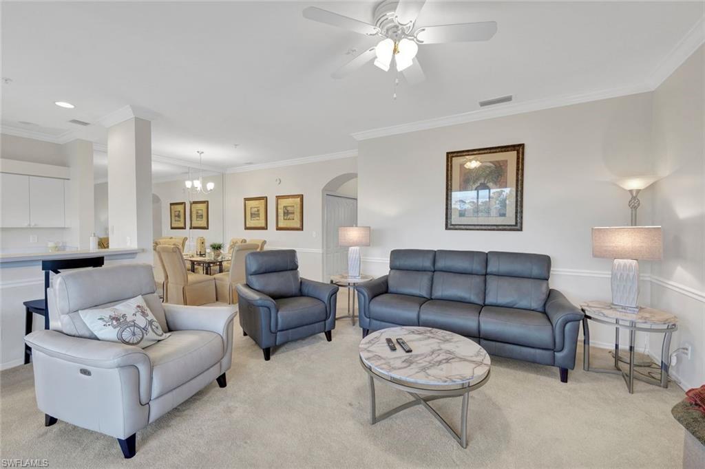 8680 Cedar Hammock Circle, Unit 142 Naples, FL 34112 - Photo 8 of 27 a living room with furniture a lamp and a window