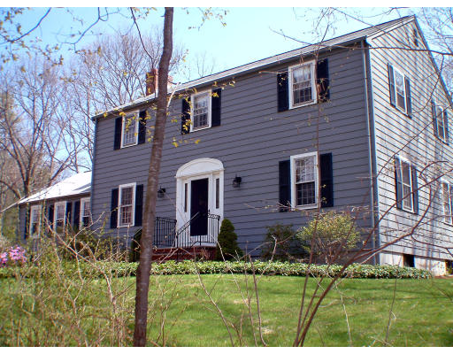 135 Raleigh Tavern Lane North Andover, MA 01845 - Photo 1 of 21 a view of a house with brick walls and a yard with plants and large trees