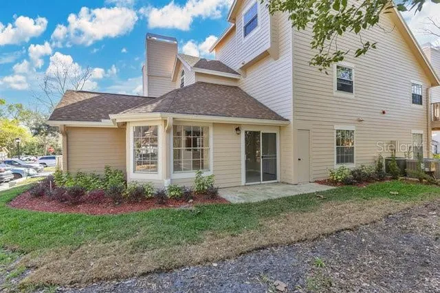 a view of a house with backyard and sitting area