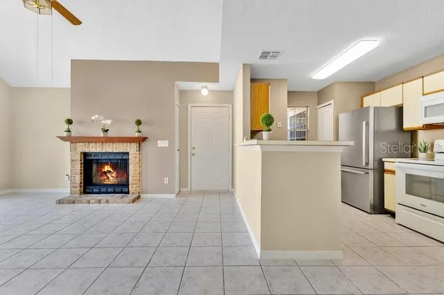 a view of a kitchen with a refrigerator a stove top oven and cabinets
