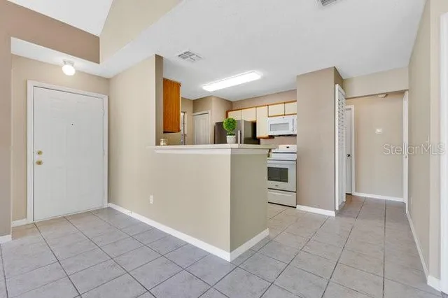 a view of an empty room with window and cabinet