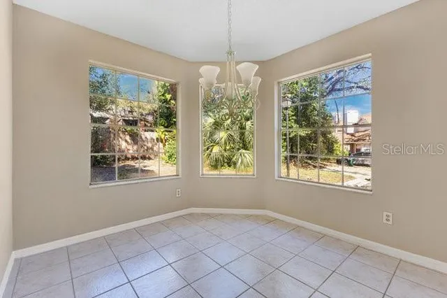 a view of a livingroom with a fireplace a chandelier a wooden table and chairs