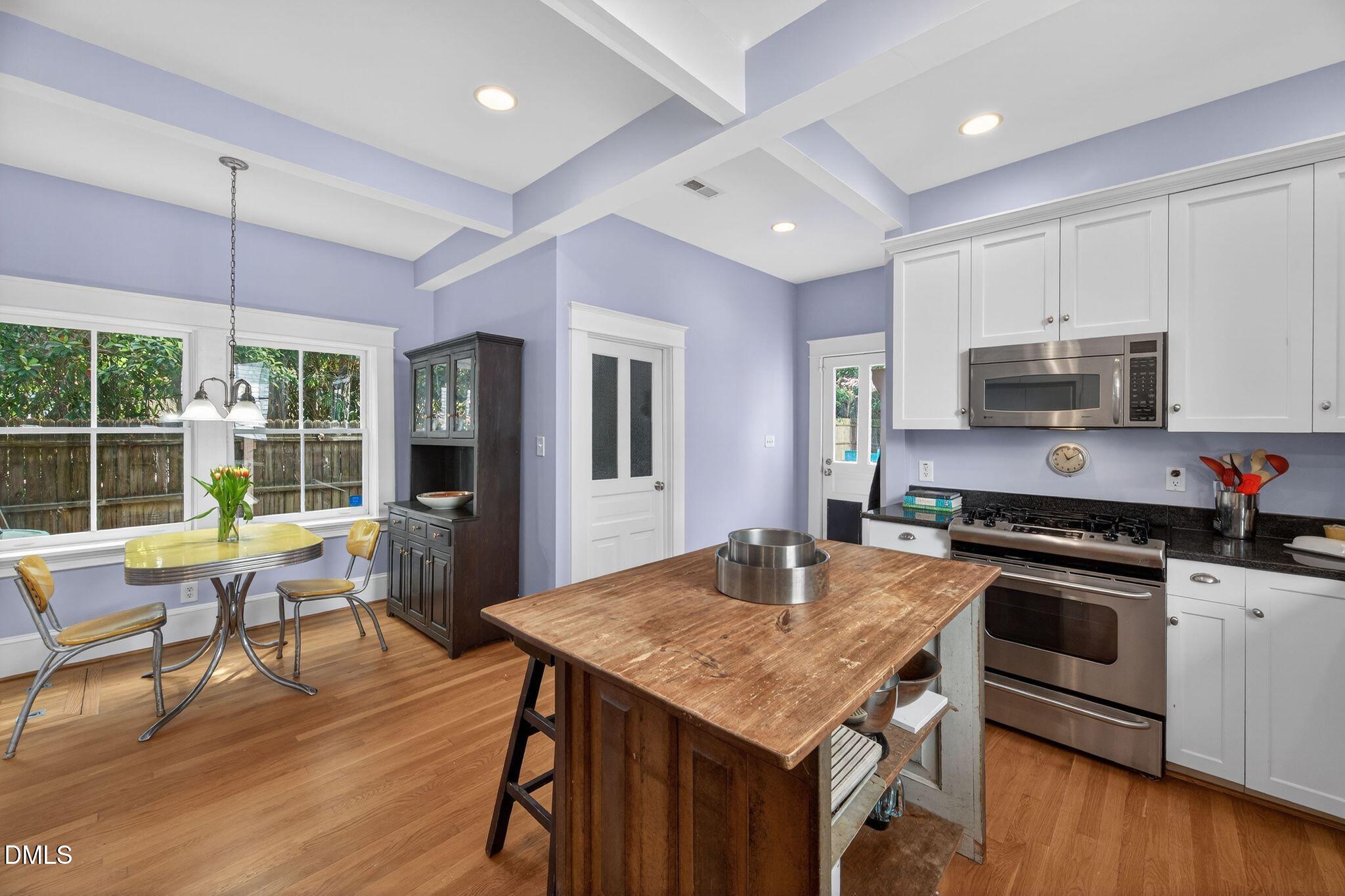 218 Pace Street Raleigh, NC 27604 - Photo 14 of 43 a kitchen with a stove a sink dishwasher a refrigerator with a dining table and chairs with wooden floor