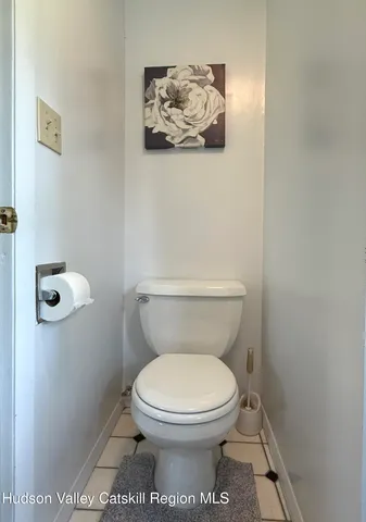 a white toilet sitting next to a white wall