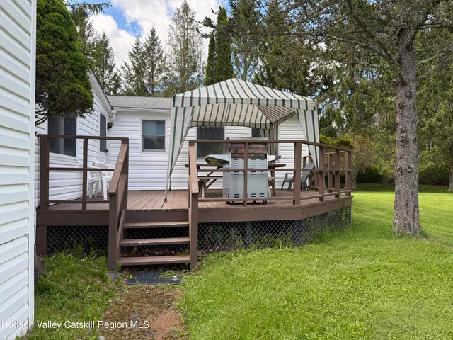 a view of a house with a yard deck and a small cabin