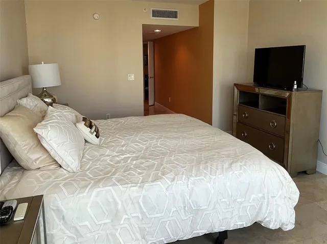 a large bed sitting in a bedroom next to a lamp