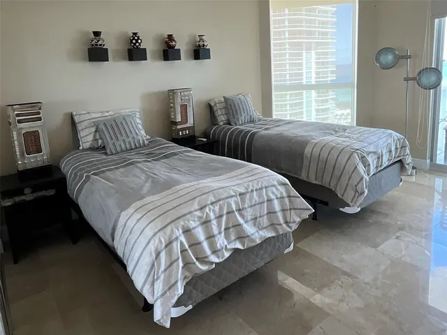 a bedroom with two beds and a lamp