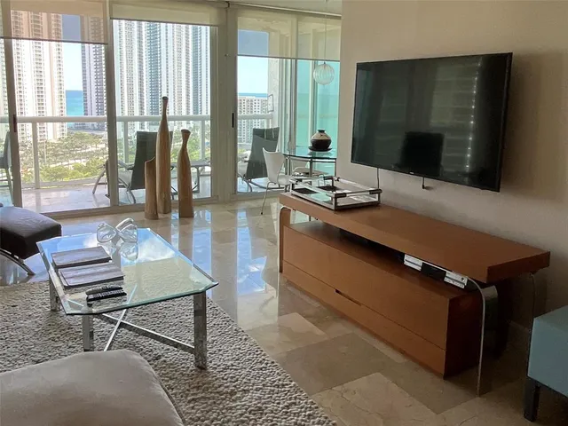a living room with a table chairs and a flat screen tv