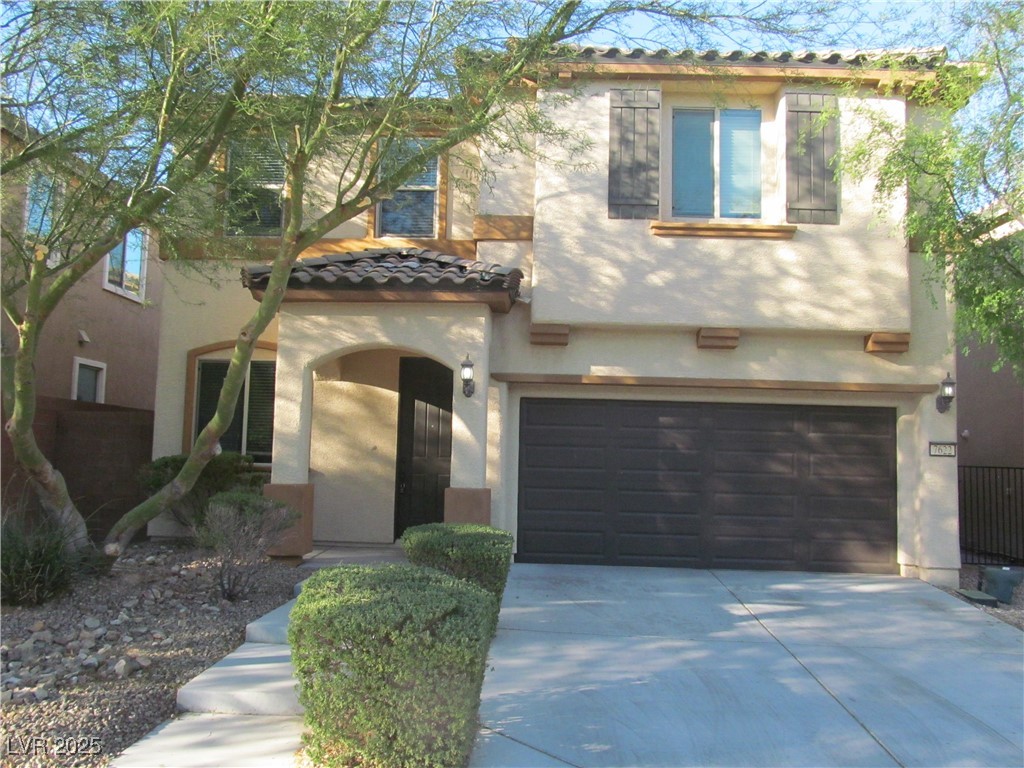 Mediterranean / spanish house with stucco siding, driveway, a garage, and a tile roof