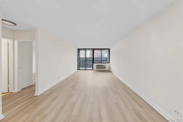 a view of a room with wooden floor and window