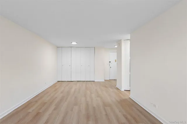 a view of an empty room with wooden floor