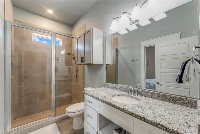 a bathroom with a granite countertop sink toilet and shower