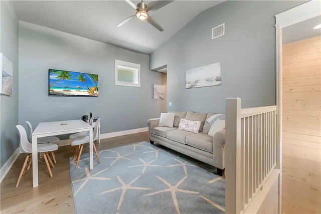 a living room with furniture a desk and chair with wooden floor