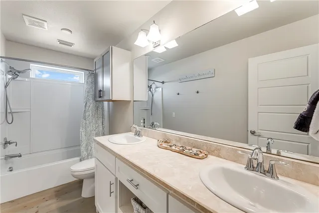 a bathroom with a granite countertop sink toilet a large mirror a shower and bathtub