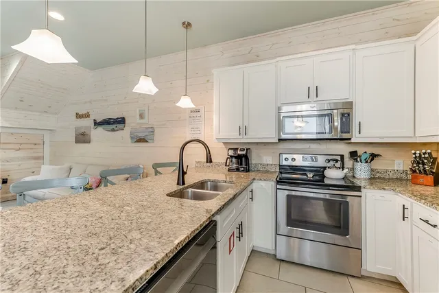 a kitchen with stainless steel appliances granite countertop a sink a stove and a wooden cabinets