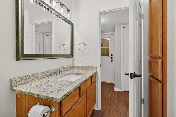 a bathroom with a granite countertop sink and a mirror
