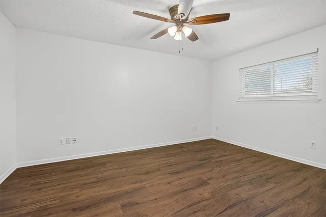 a view of a big room with wooden floor and a ceiling fan