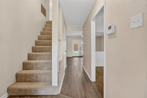 a view of a hallway with wooden floor and stairs