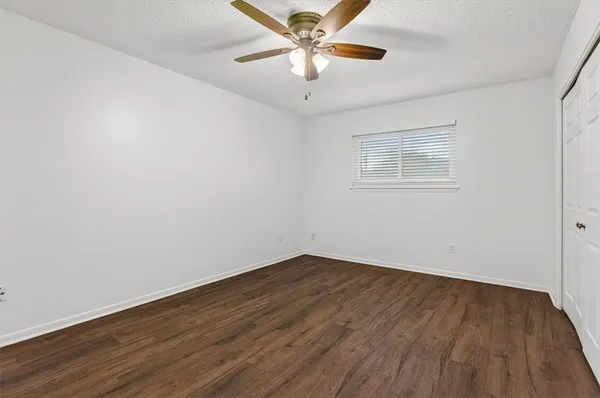 a view of a big room with wooden floor and a ceiling fan